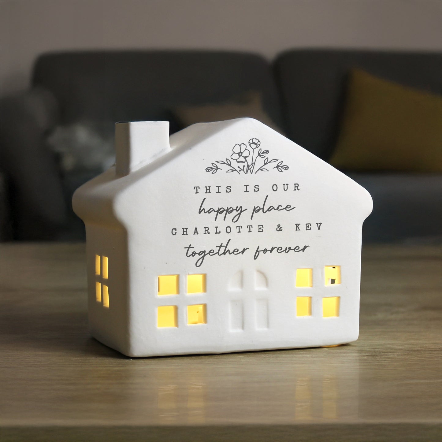 House-shaped night light with personalized text on a wooden surface