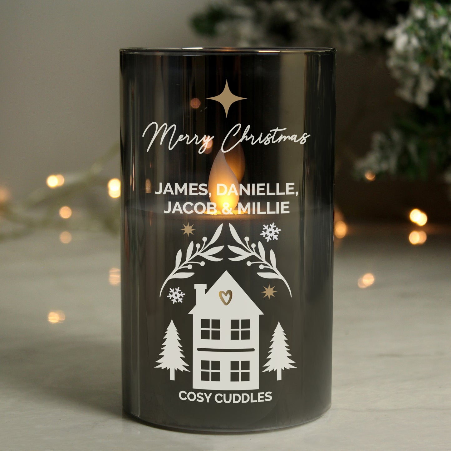 Black candle holder with personalised text and house illustration on a blurred background