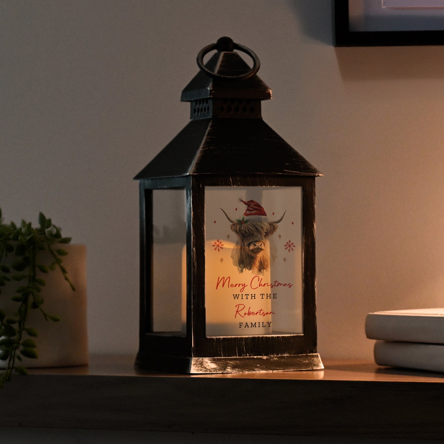 Decorative lantern with a Christmas card inside on a table.