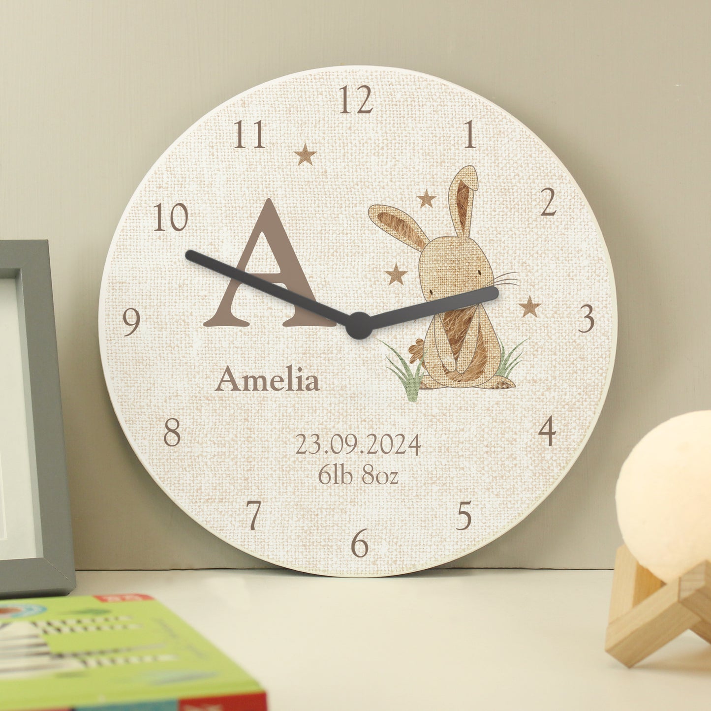 Wall clock with a rabbit illustration and personalised text on a neutral background