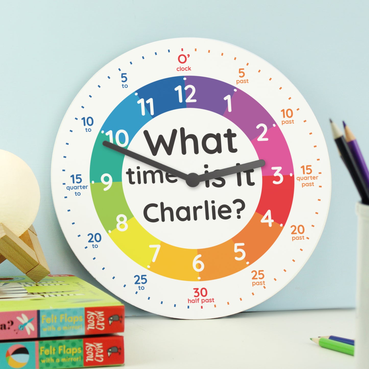 Colourful clock with 'What time is it Charlie?' text on a light blue background