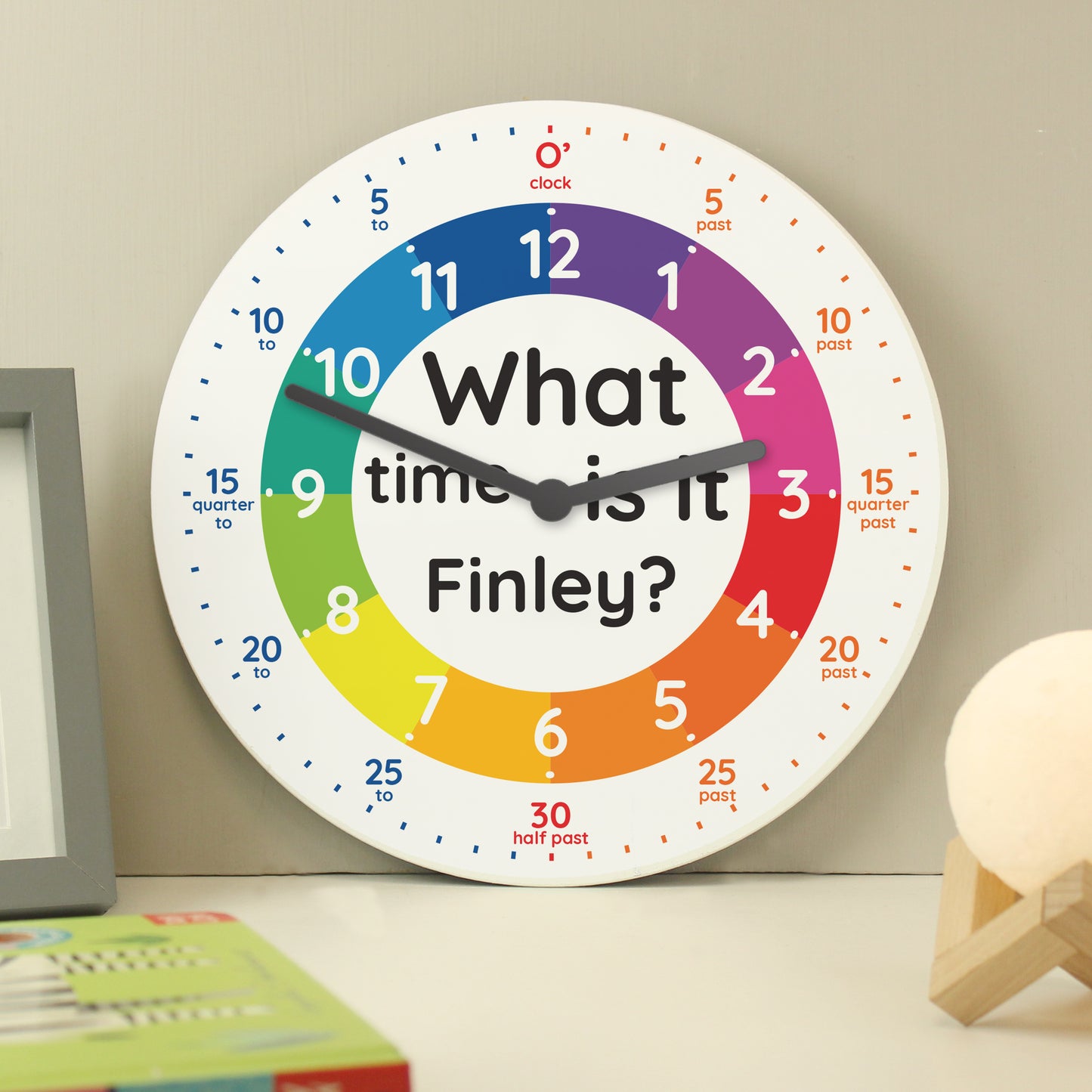 Colourful clock with 'What time is it Finley?' text on a wall.