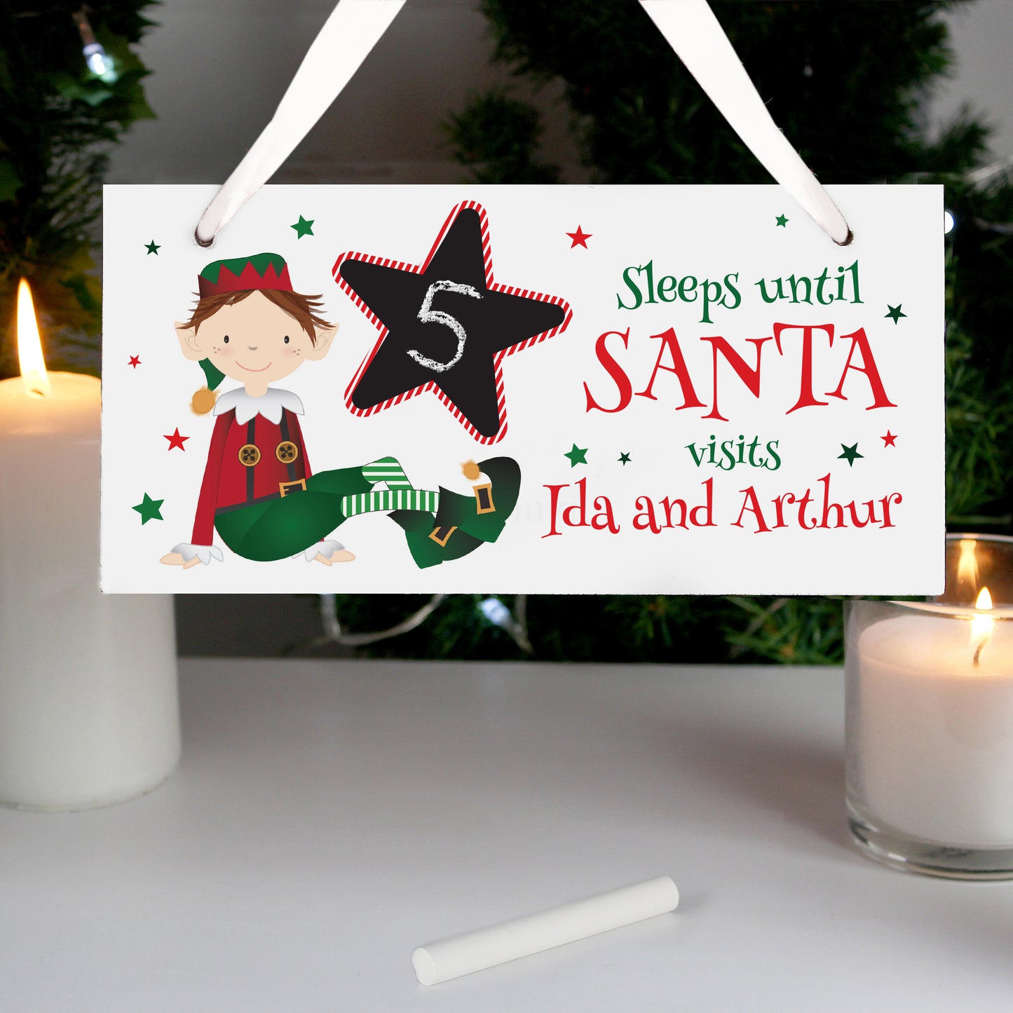 Christmas countdown sign with elf design and candles on a table