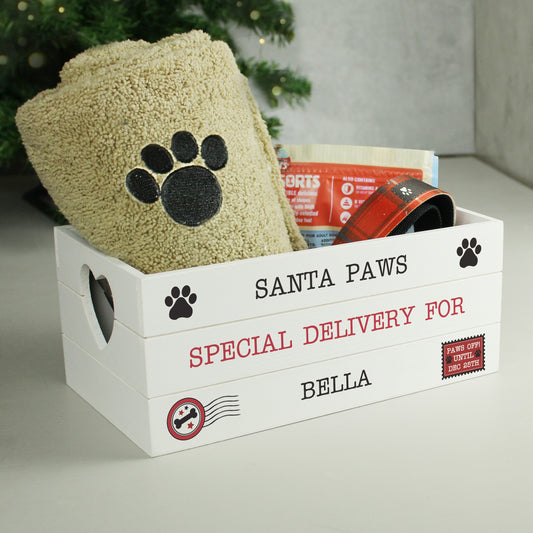 White box labeled 'Santa Paws' with pet supplies inside, featuring a paw print design.