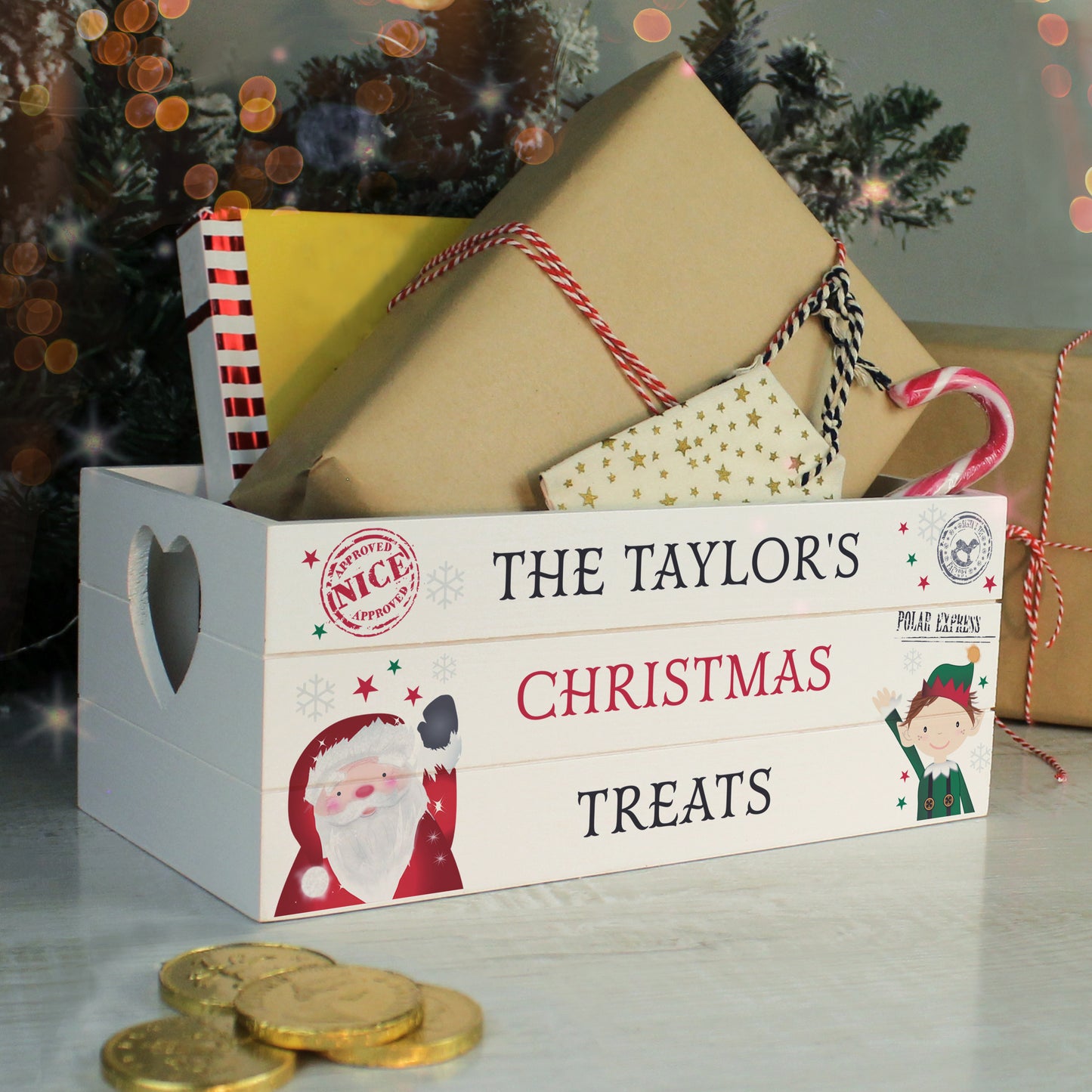 Christmas-themed treat box with personalised name 'The Taylor's' and festive design, surrounded by gold coins and a candy cane.