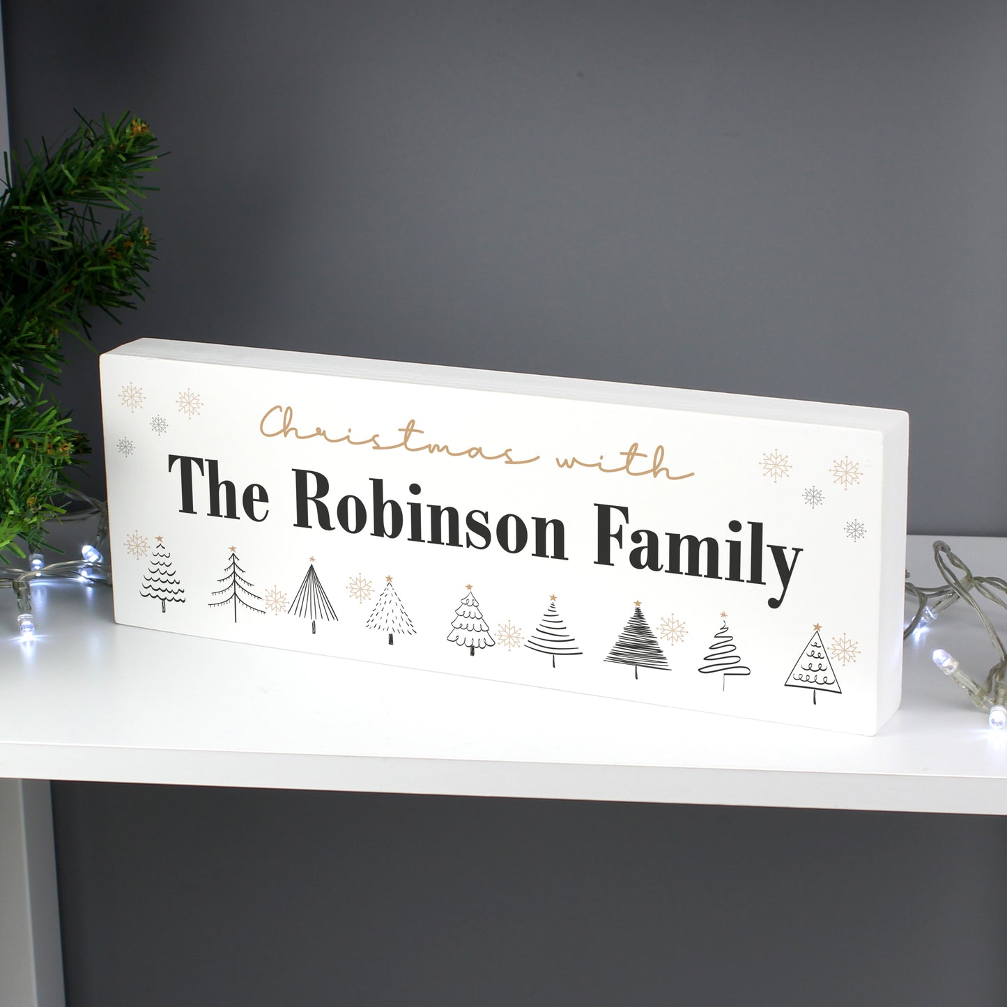Decorative Christmas sign with 'The Robinson Family' text on a white surface.