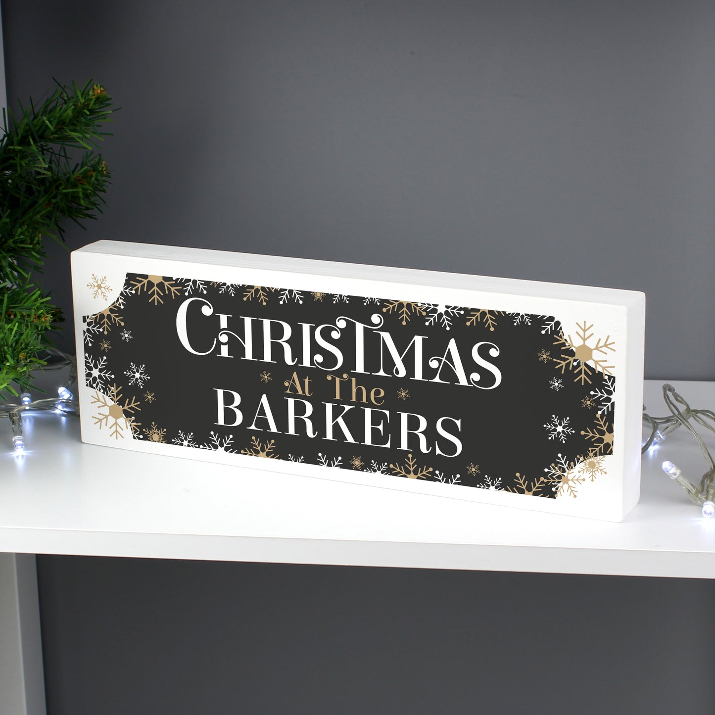 Decorative sign with 'Christmas at The Barkers' text on a dark background, placed on a white surface.