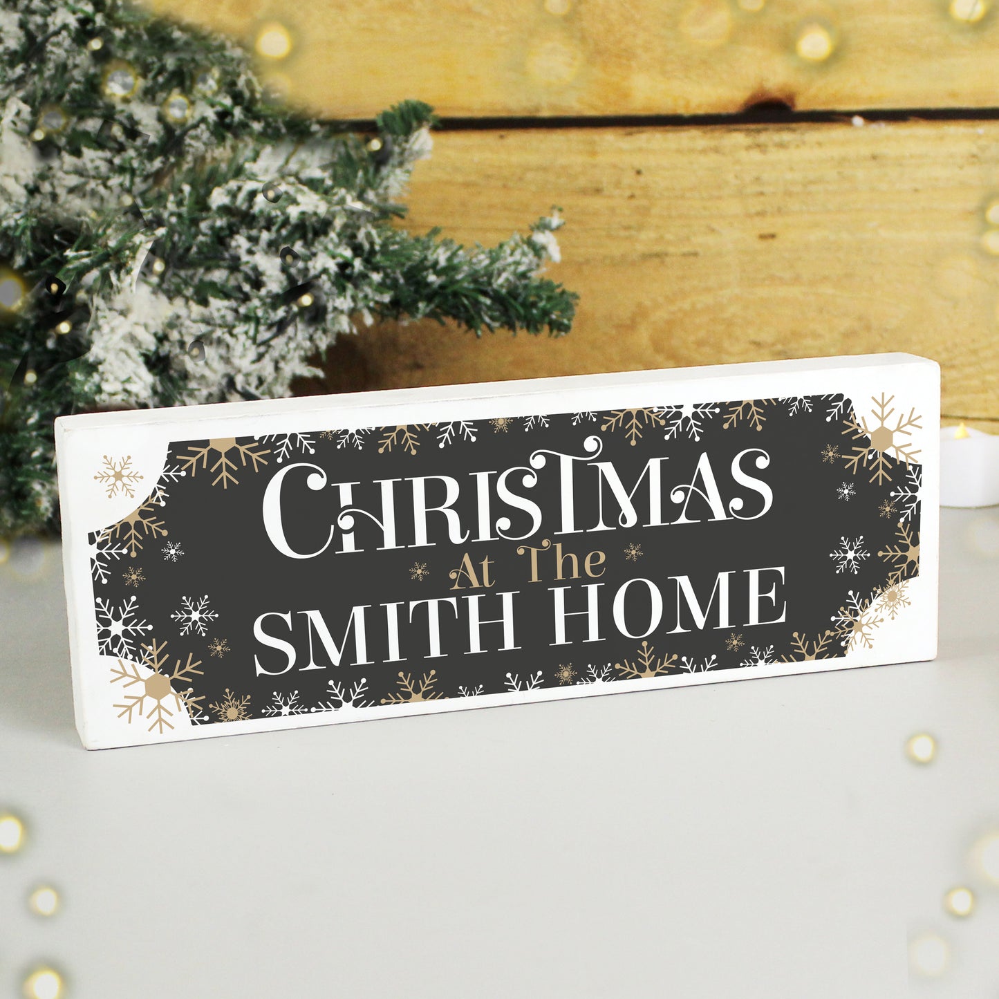 Decorative Christmas sign with 'Christmas at the Smith Home' text, snowflakes, and a wooden background.