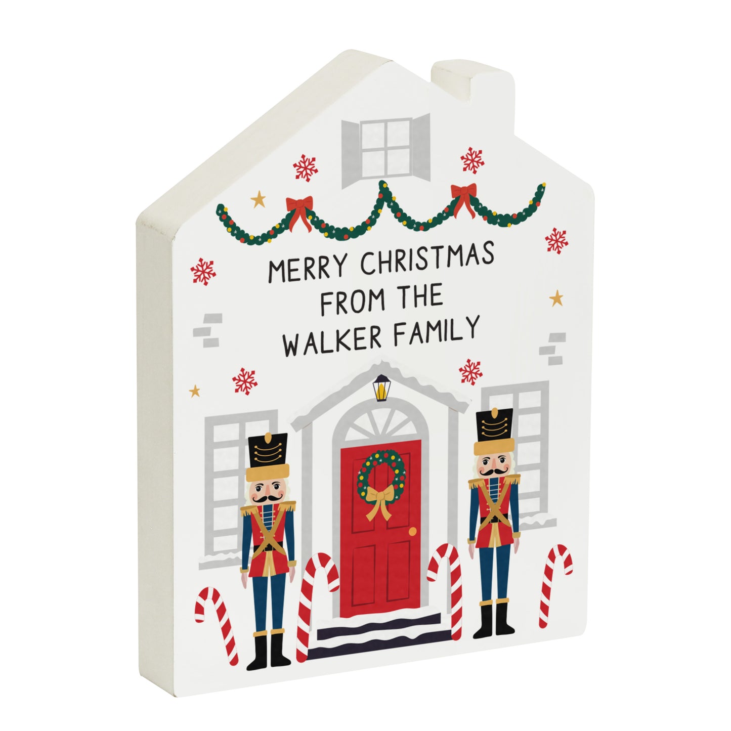 Decorative Christmas house-shaped sign with 'Merry Christmas from the Walker Family' text, nutcrackers, and candy canes on a white background.