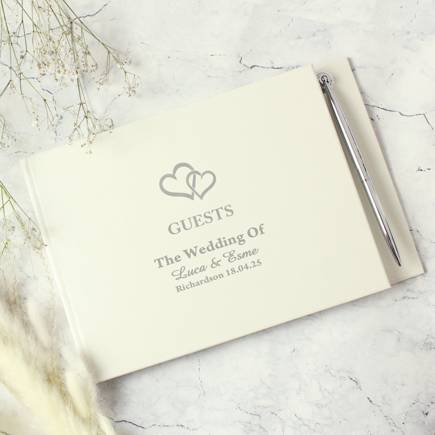 Wedding guest book with pen on a marble surface