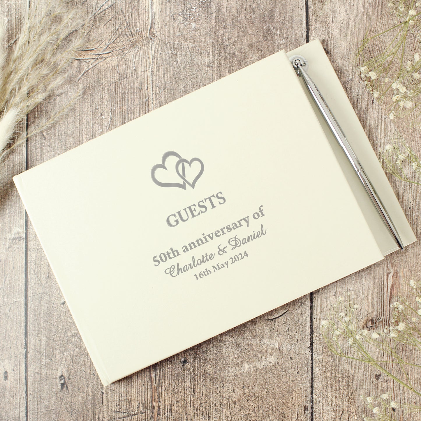 Personalised guest book for a 50th anniversary on a wooden surface with decorative elements.
