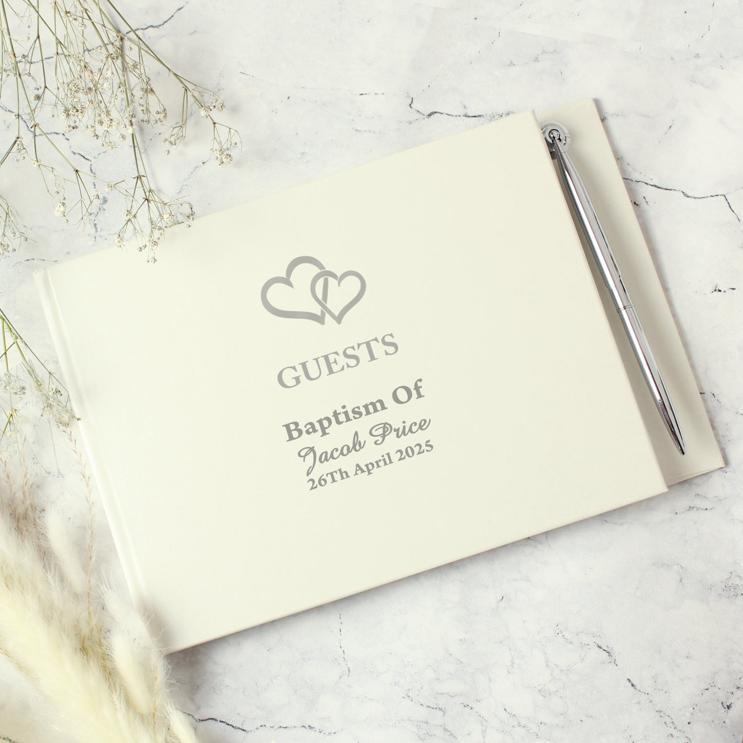 Guestbook with pen on a marble surface with baby's breath flowers
