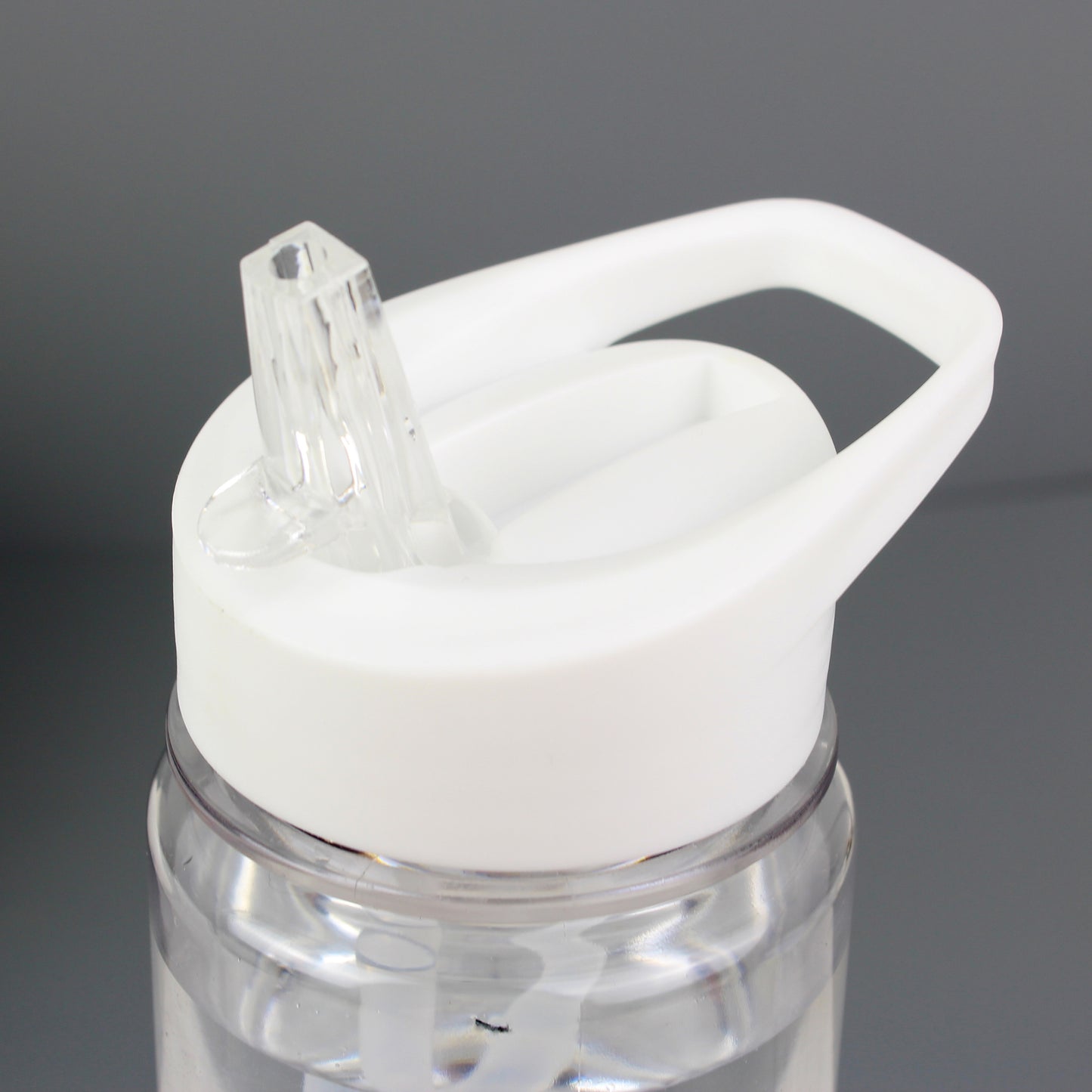 Clear water bottle with a white cap on a grey background