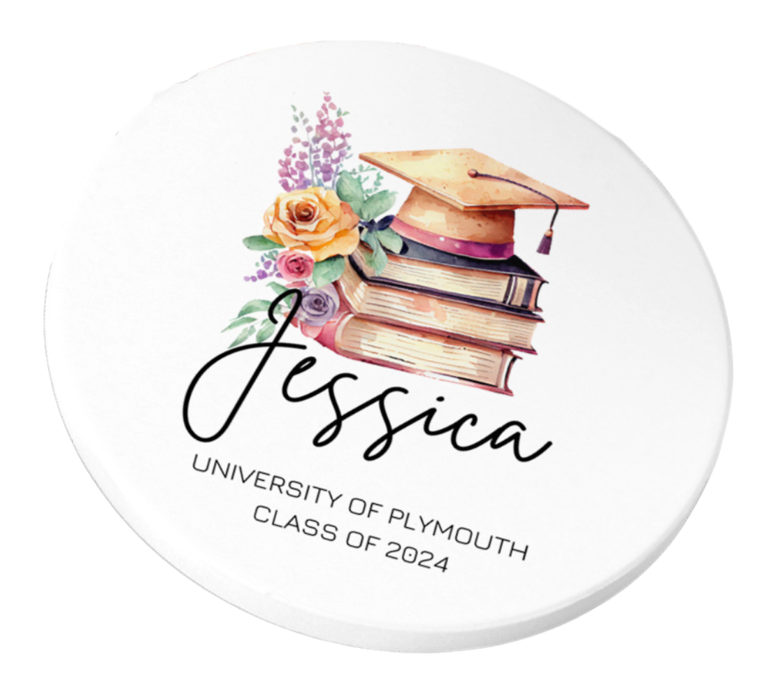 A round white coaster featuring a watercolor illustration of a graduation cap on a stack of books, decorated with roses and lavender flowers. Below the image, the name "Jessica" appears in black script, with the words "University of Plymouth, Class of 2024" printed underneath in clean uppercase text. The coaster is displayed on a light wood surface beside other matching coasters.