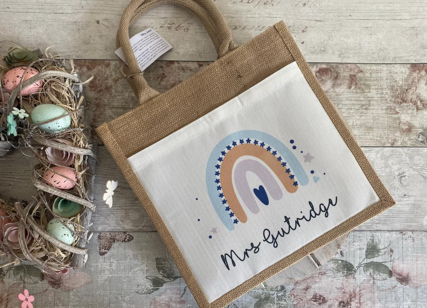 Small bag with a rainbow design and text on a wooden surface with decorative elements.
