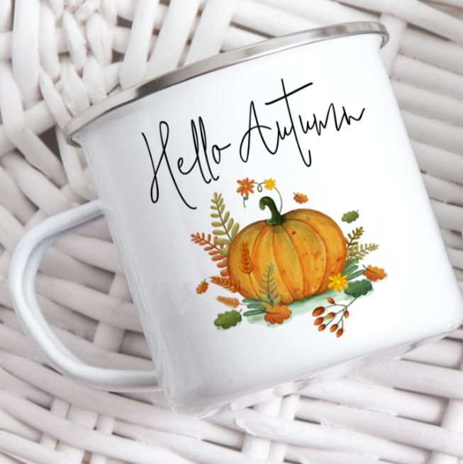 White mug with 'Hello Autumn' text and pumpkin design on a white woven background