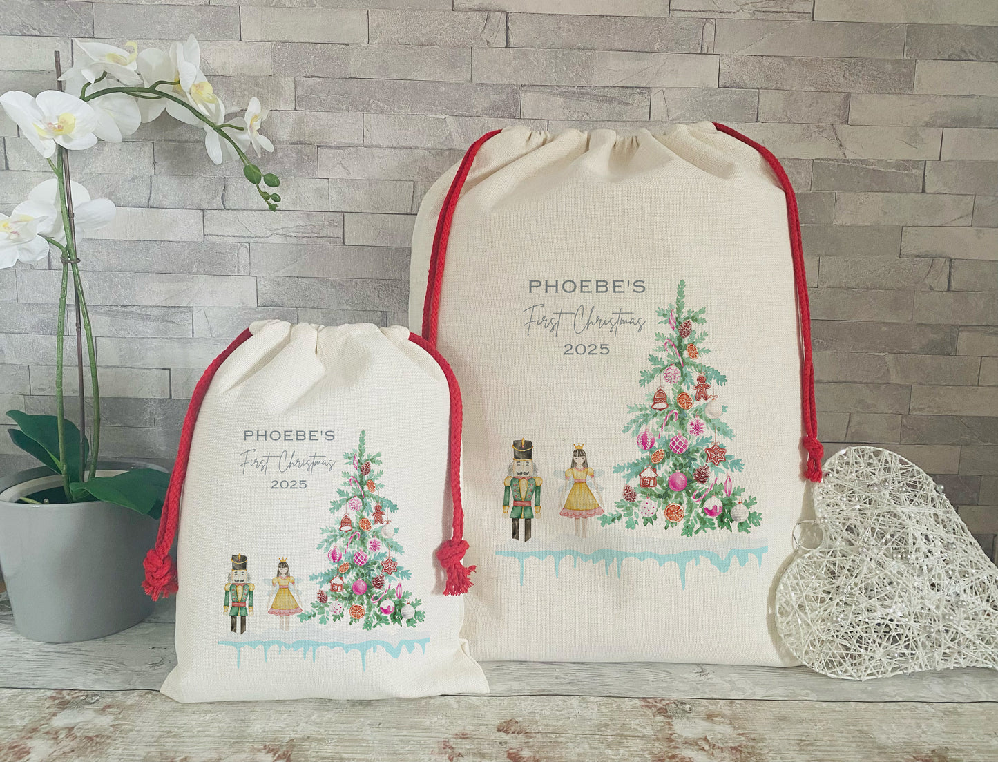 Two drawstring bags with Christmas-themed designs and text on a wooden surface.