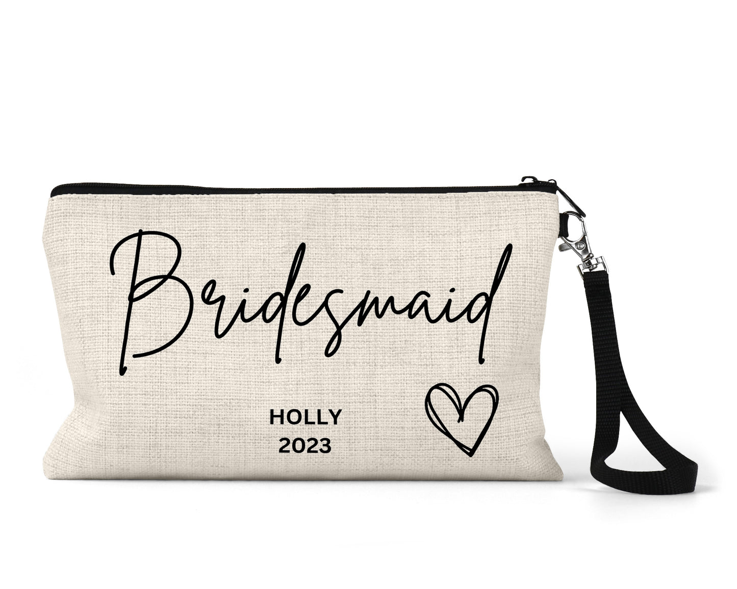 A beige zippered clutch bag with the text "Bridesmaid" in large cursive script, and "Holly 2023" in smaller capital letters, featuring a heart design on the right. The bag has a black wrist strap attached.