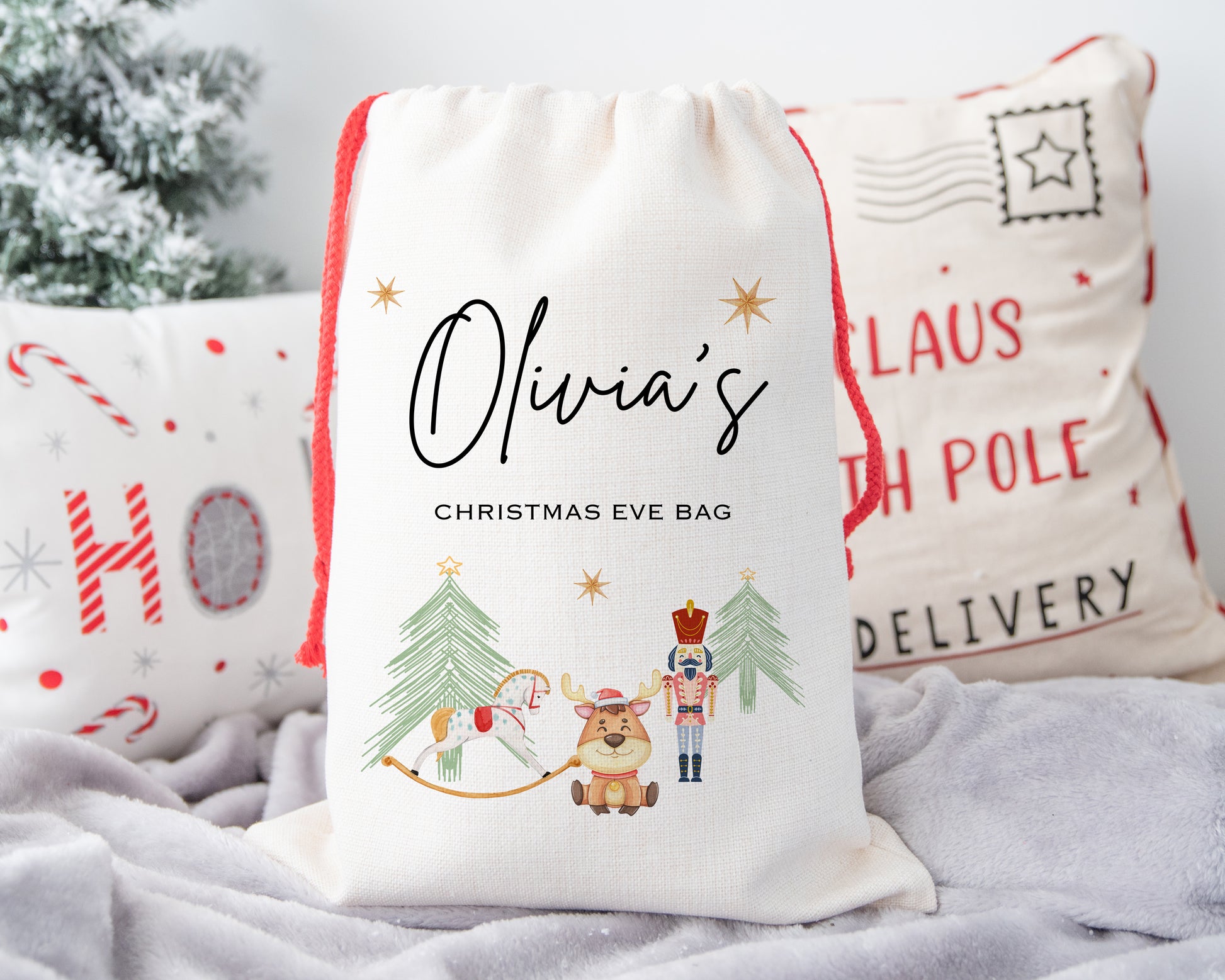 Personalised children's Christmas Eve bag with name Olivia, festive drawstring sack featuring rocking horse, nutcracker, and reindeer, ideal for kids Christmas Eve tradition gift sack