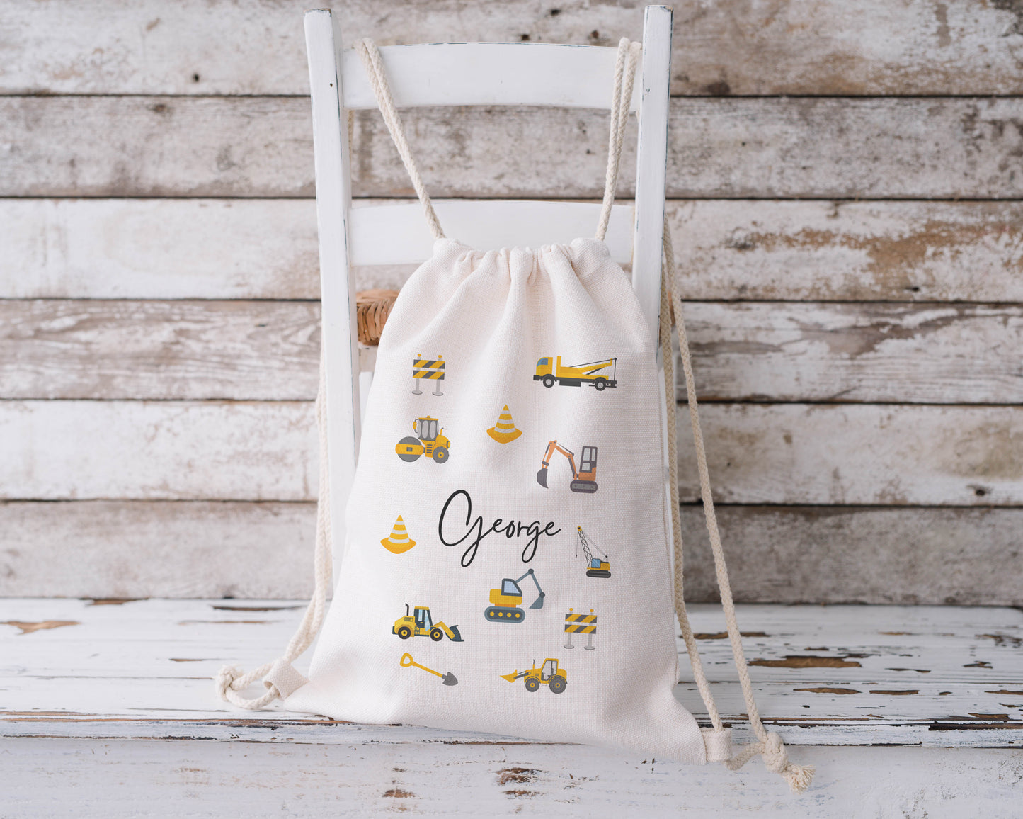 Personalised construction-themed drawstring backpack with yellow diggers, trucks, cranes, and cones – custom name ‘George’, perfect for nursery or school use