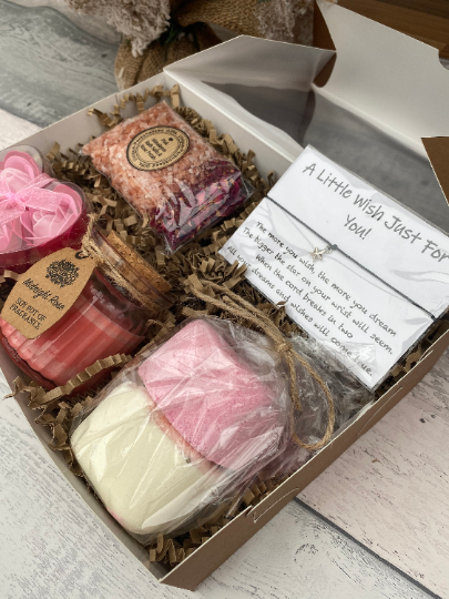 Gift set with candles and soap in a box on a wooden surface
