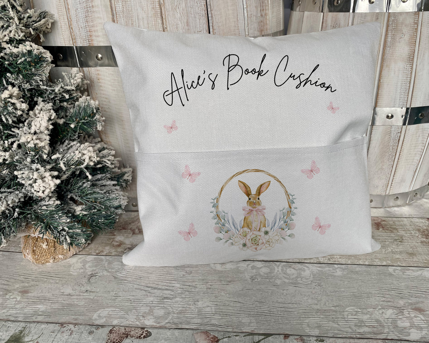 Personalised Easter book cushion featuring a cute bunny design with floral wreath and pink butterflies – a unique and thoughtful gift for children’s reading time or Easter celebrations.