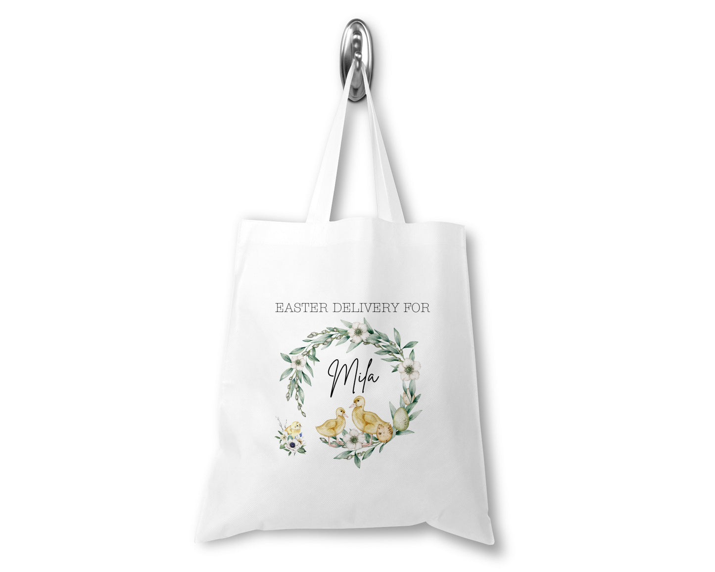 Personalised Easter delivery tote bag with cute yellow chicks, floral wreath, and custom name "Mila" on white cotton fabric. Perfect for Easter egg hunts, gifting, or spring celebrations. Eco-friendly reusable Easter bag for children.