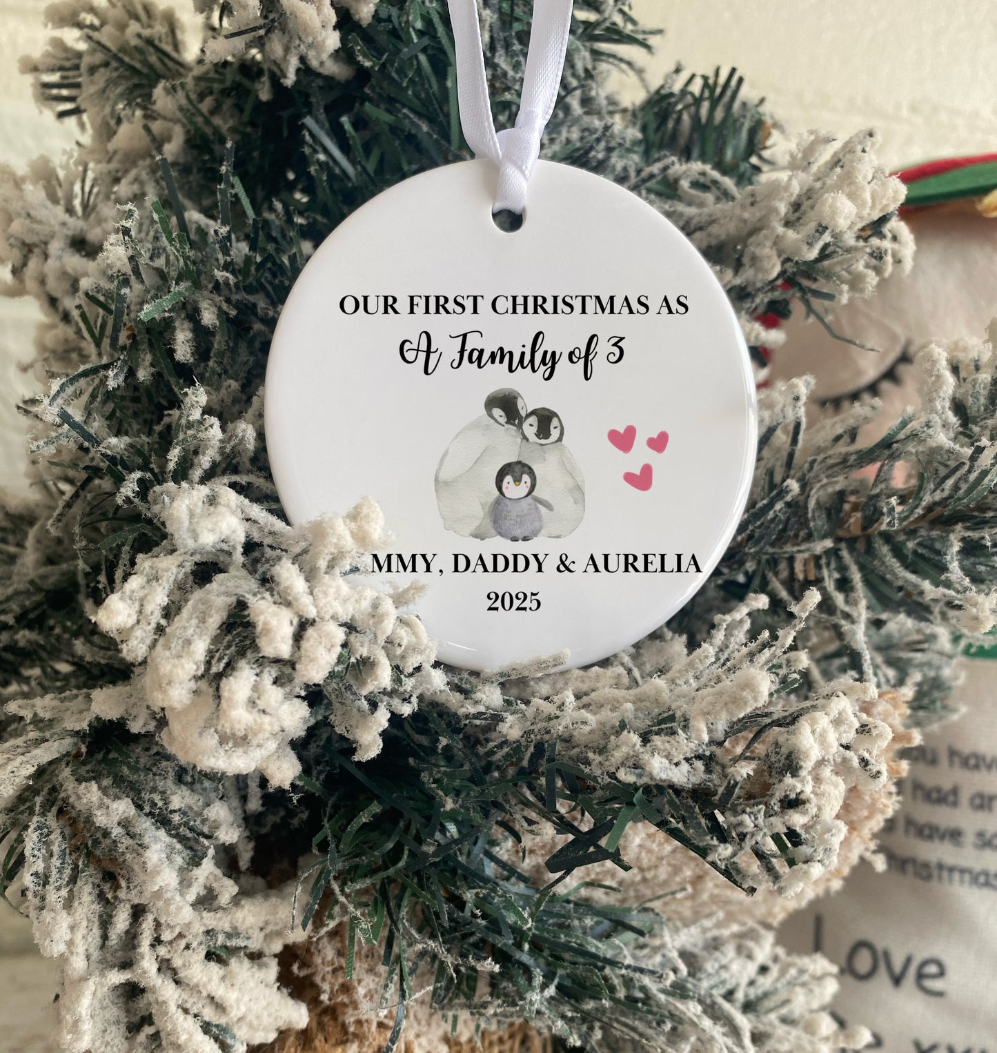 Personalized Christmas ornament with penguins on a decorated tree
