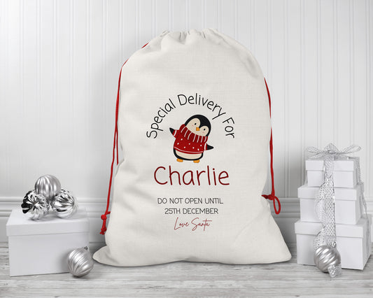 Personalised Christmas gift sack with cute penguin design – custom linen Santa sack for kids with red drawstring – “Special Delivery for Charlie” print