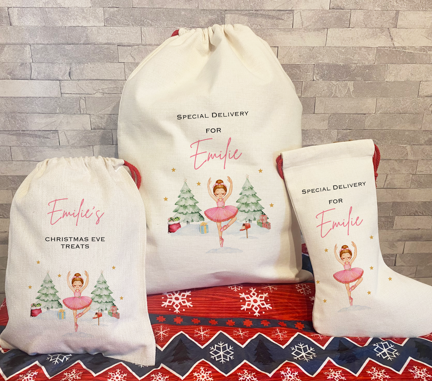 Set of three personalised Christmas gifts for Emilie featuring a matching pink ballerina design ā includes a Christmas Eve treat bag, large sack, and stocking, all with festive illustrations of snowy trees, presents, and gold stars.