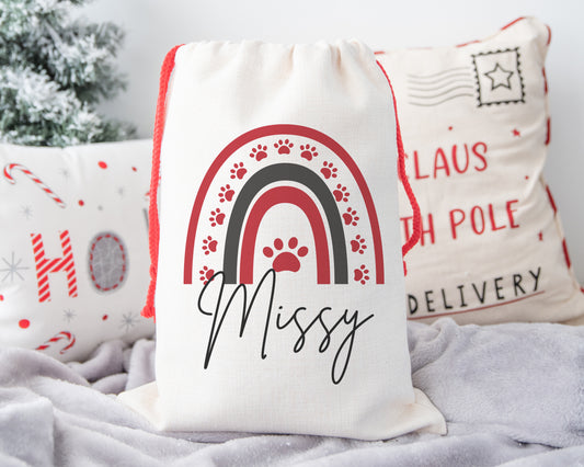 Personalised pet Christmas sack with red drawstring, rainbow paw print design and Missy's name on linen Santa bag