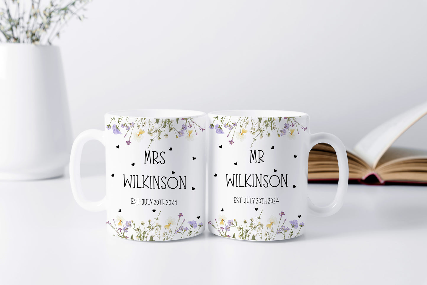 Matching white mugs with floral designs and the names "MR & MRS WILKINSON" along with the wedding date "EST. JULY 20TH 2024."