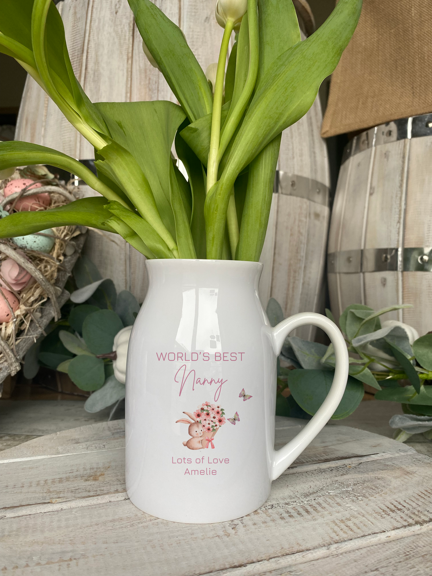 White ceramic vase with handle, featuring bunny holding flowers and butterflies, personalised with name and message for Nanny