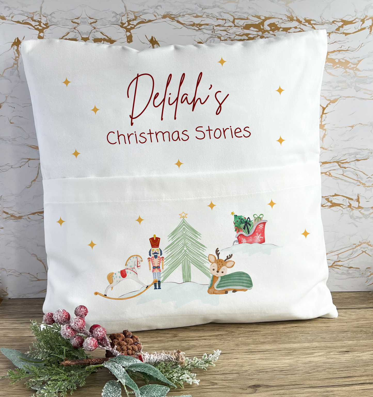 Personalised white Christmas cushion with 'Delilah's Christmas Stories' printed in festive red lettering, featuring cute illustrations of a rocking horse, nutcracker, Christmas tree, reindeer, and Santa’s gift sack, perfect for children's holiday reading time.