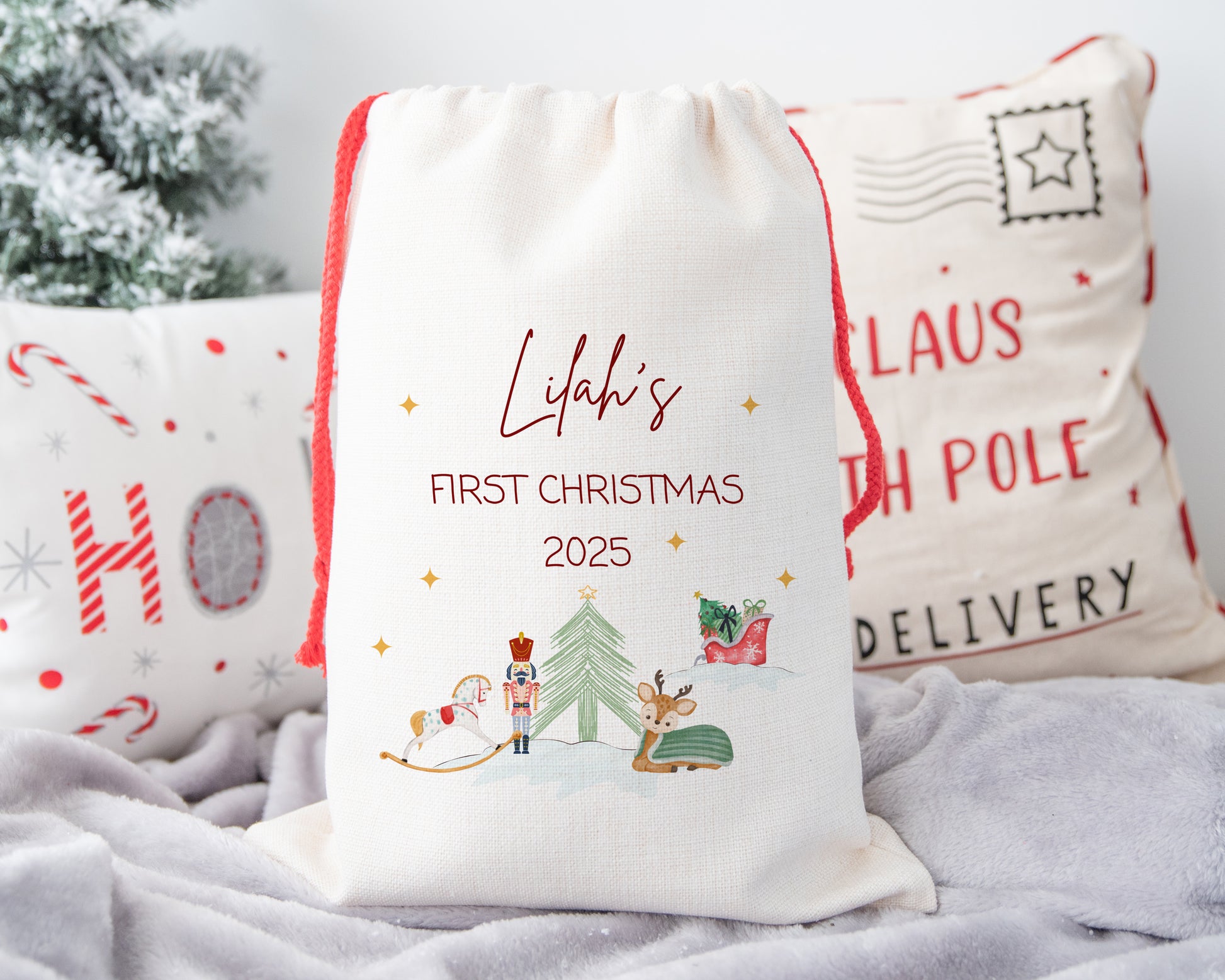 Personalized Christmas gift bag with festive design and text on a soft surface.