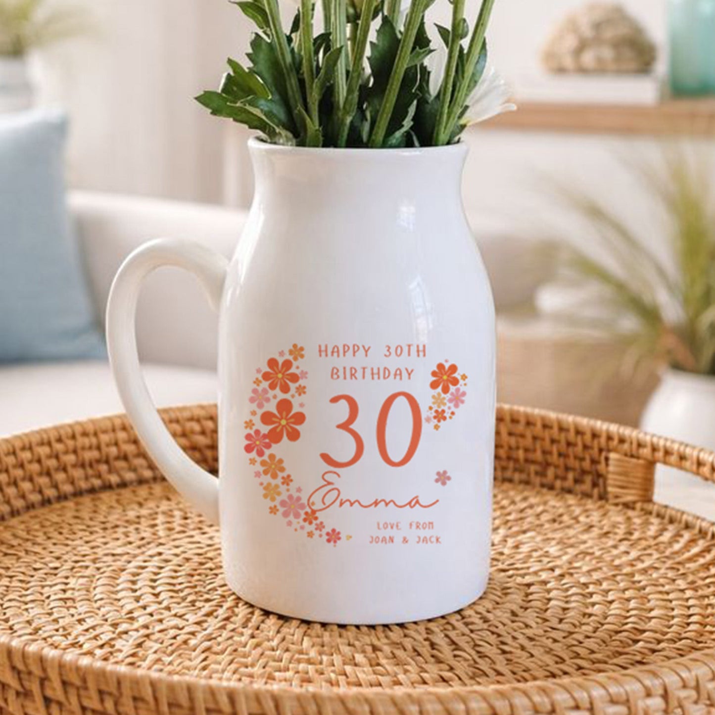 White pitcher with floral design on a woven tray in a living room setting