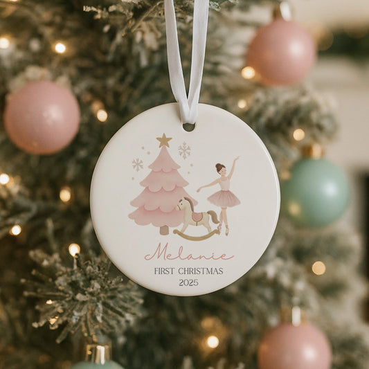 Decorative Christmas ornament with a child and tree design hanging on a tree.