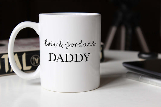 Personalised White mug with 'Eve & Jordan's DADDY' text on a blurred background