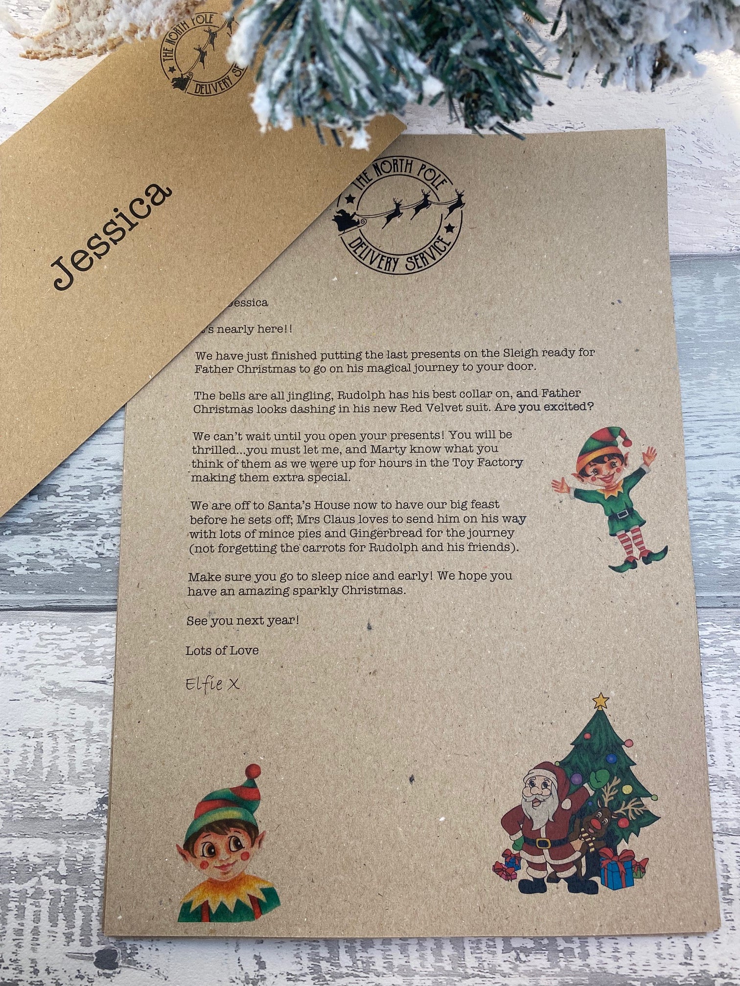 Personalised Kraft paper letter with Christmas-themed illustrations on a wooden surface.