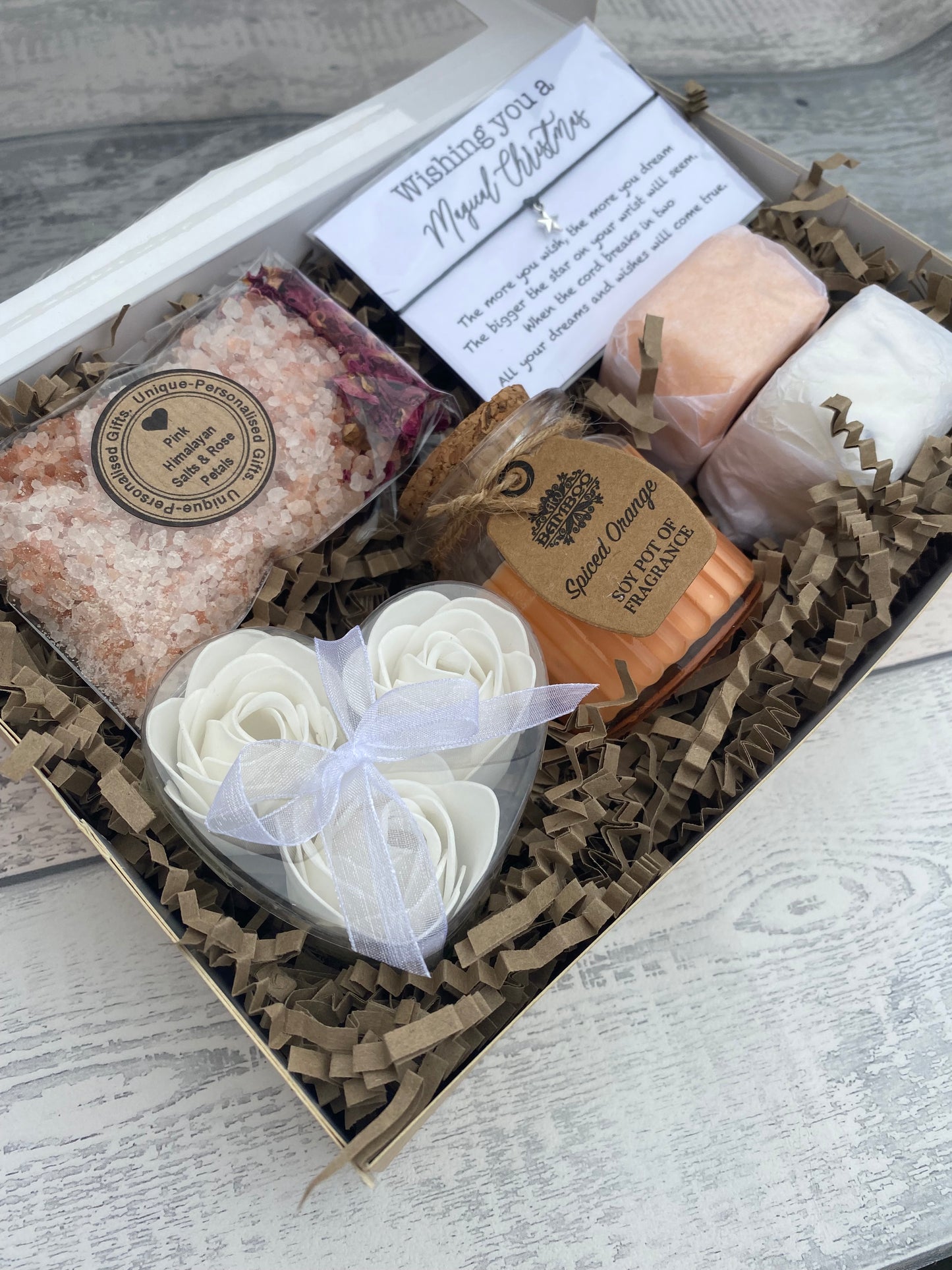 Gift set with bath bombs, soap, and other items in a box on a wooden surface