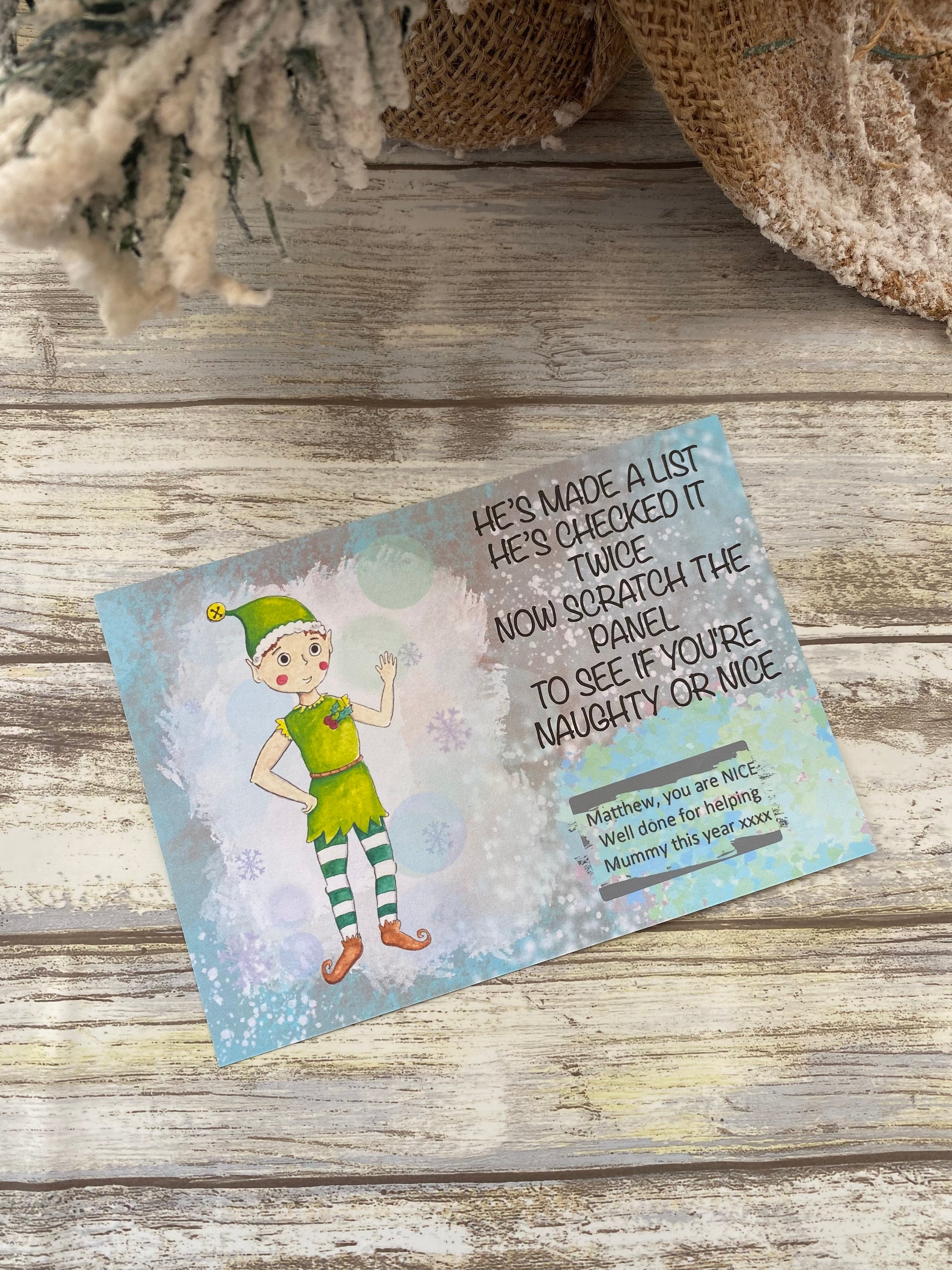 Elf-themed Scratch card on a wooden surface with text