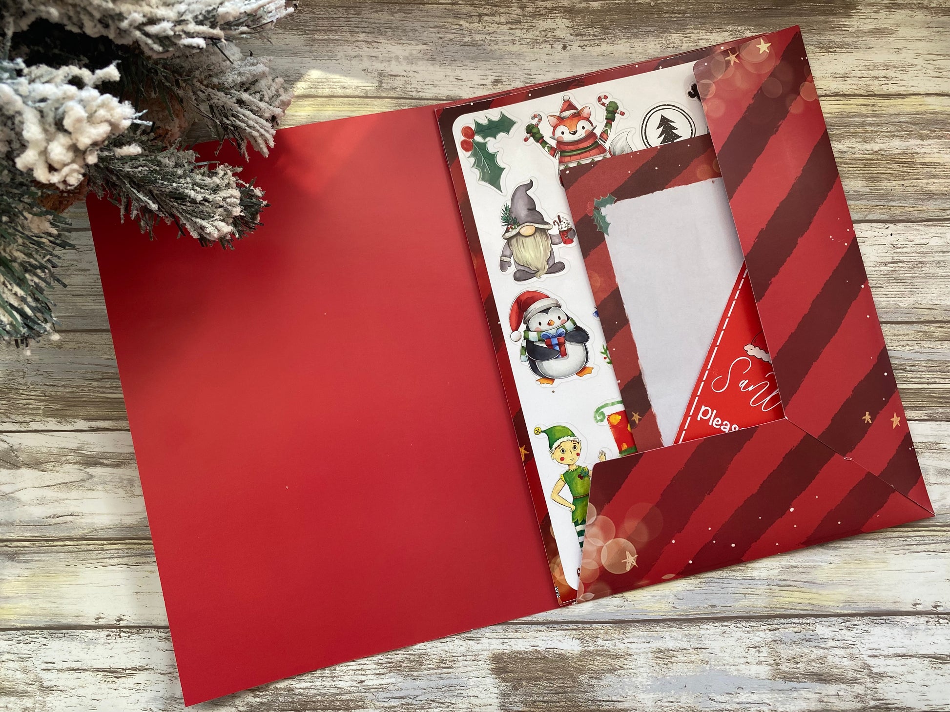 Red envelope with Christmas-themed stickers on a wooden surface