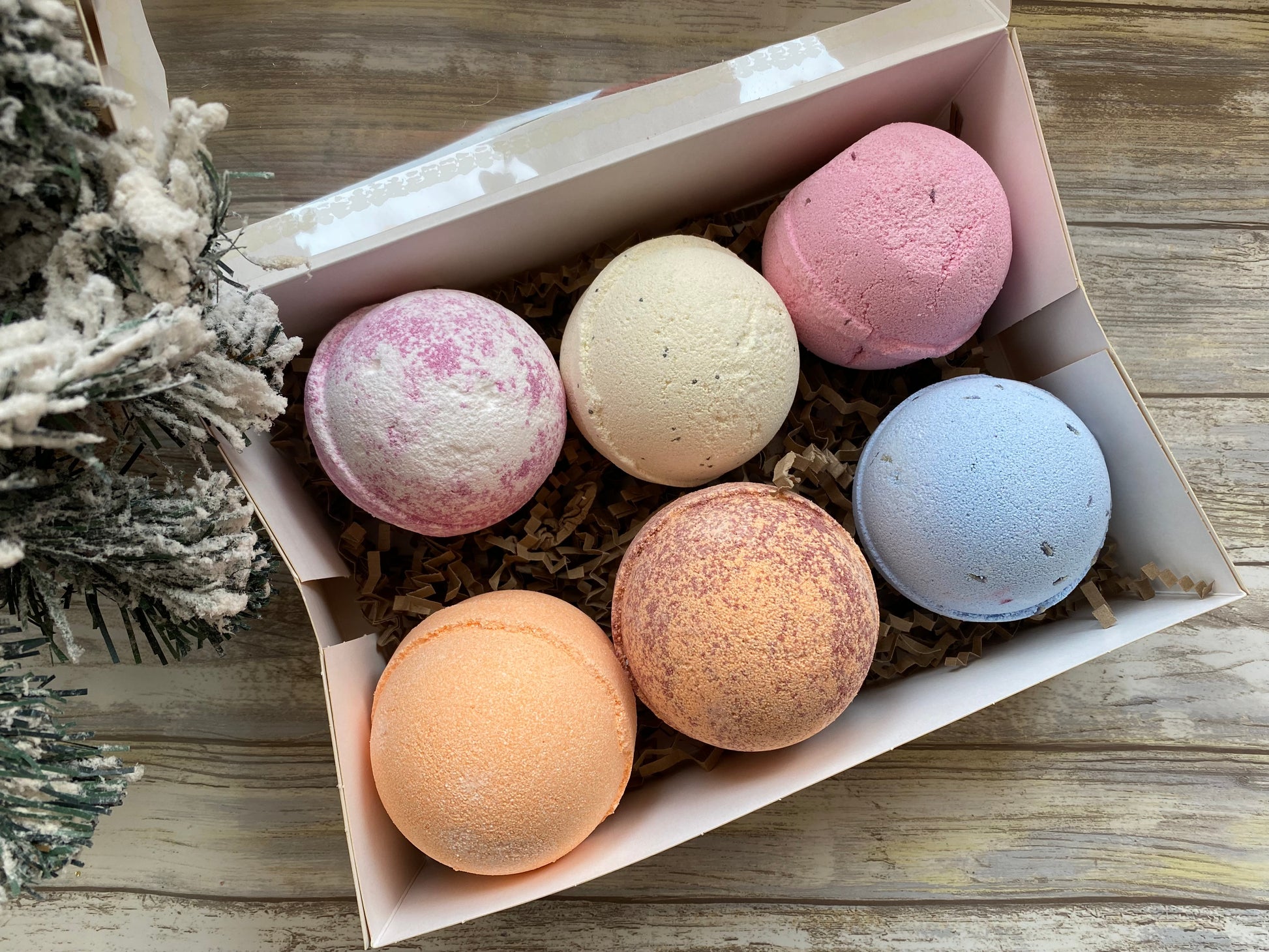 Box of colorful bath bombs on a wooden surface