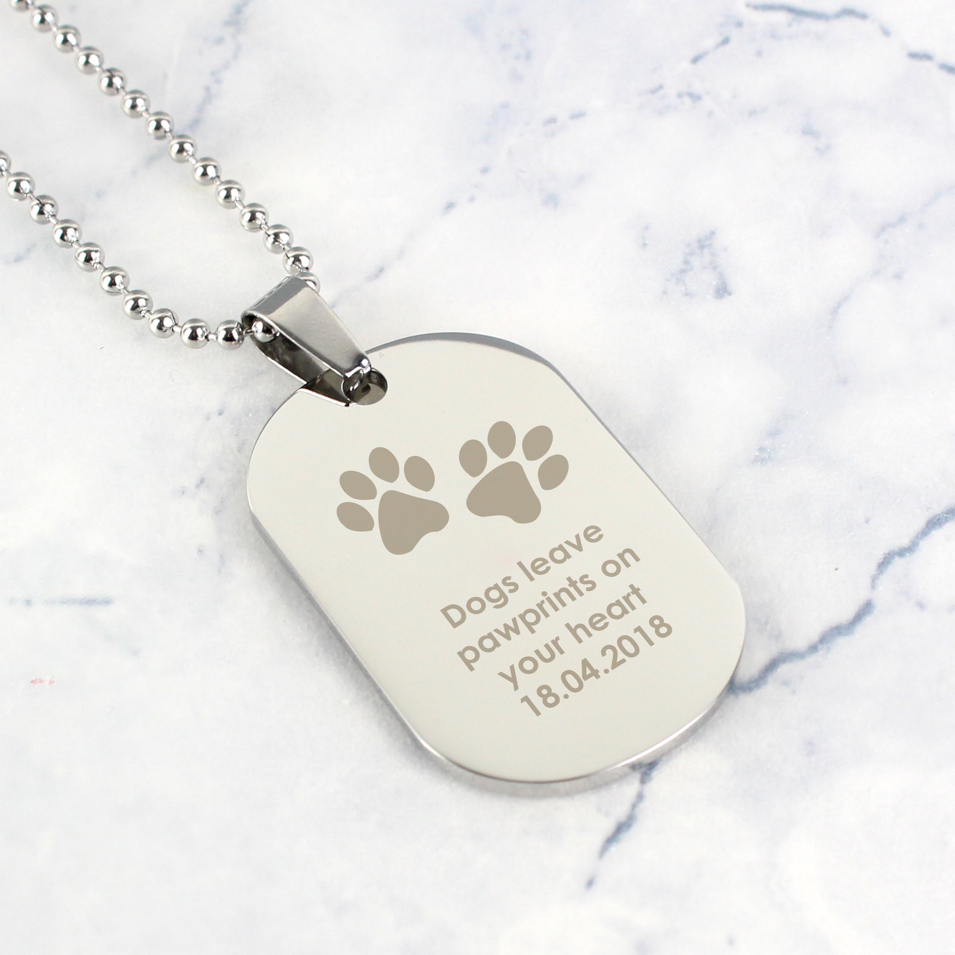 Dog tag necklace with engraved text on a marble background