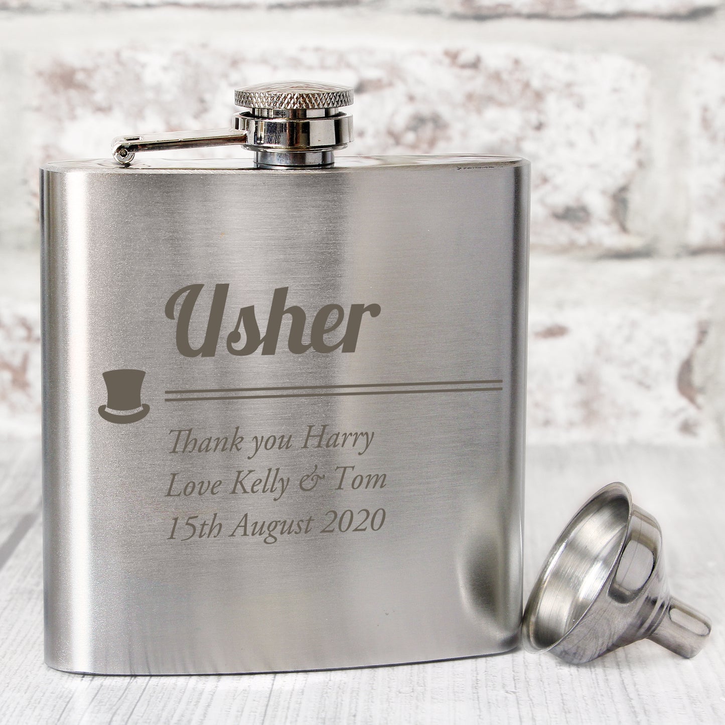 Stainless steel flask with engraved text on a light background