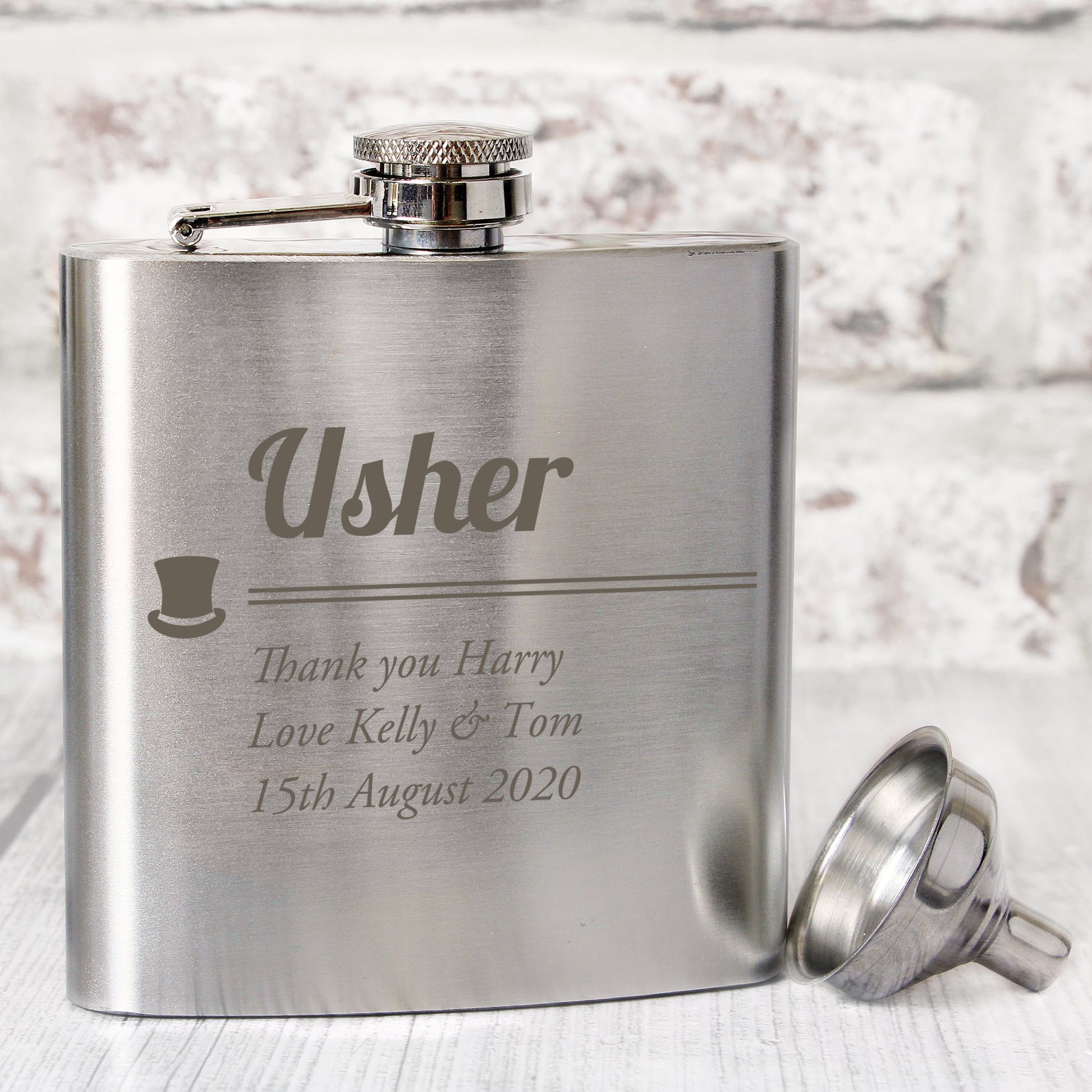 Stainless steel flask with engraved text on a light background