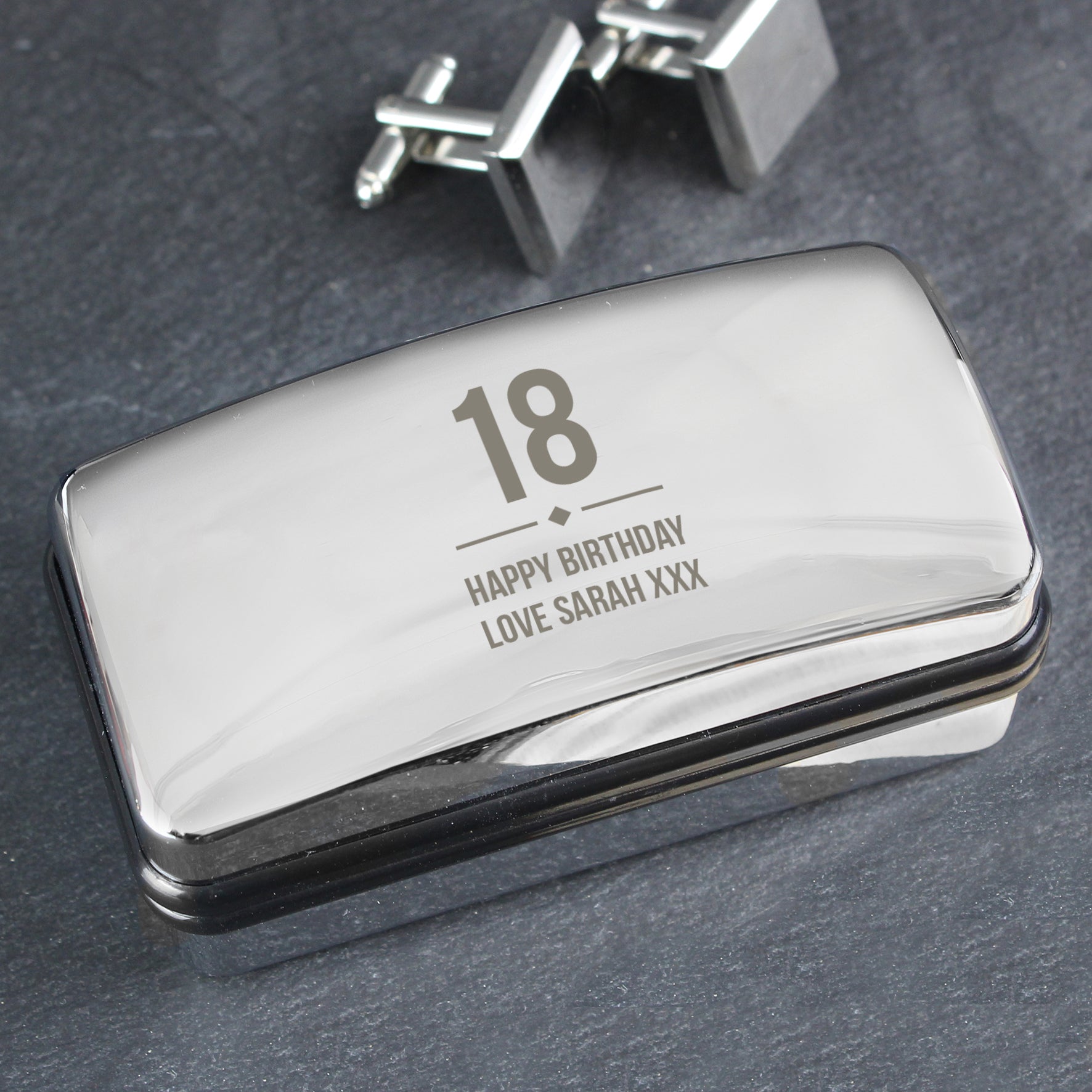 Personalised Silver cufflink box with '18 Happy Birthday Love Sarah XXX' engraving on a dark surface