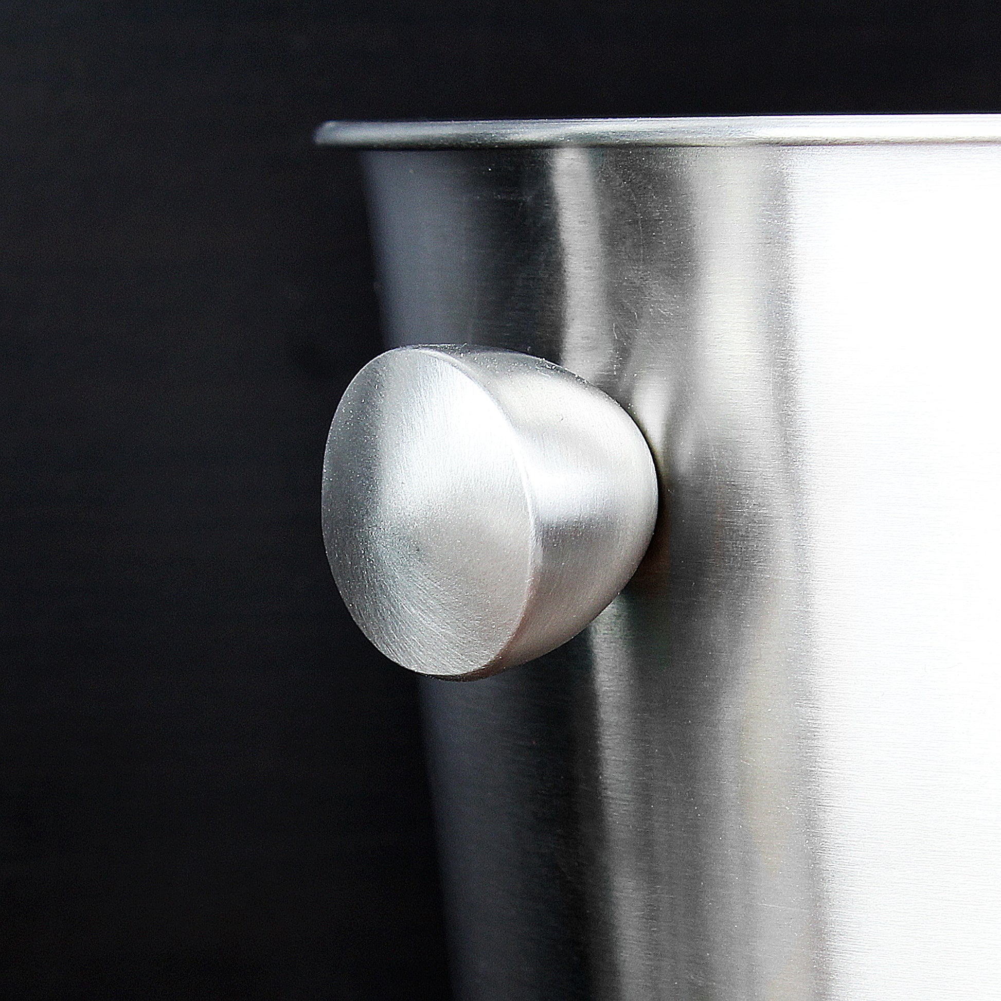 Close-up of a metallic knob on a dark background