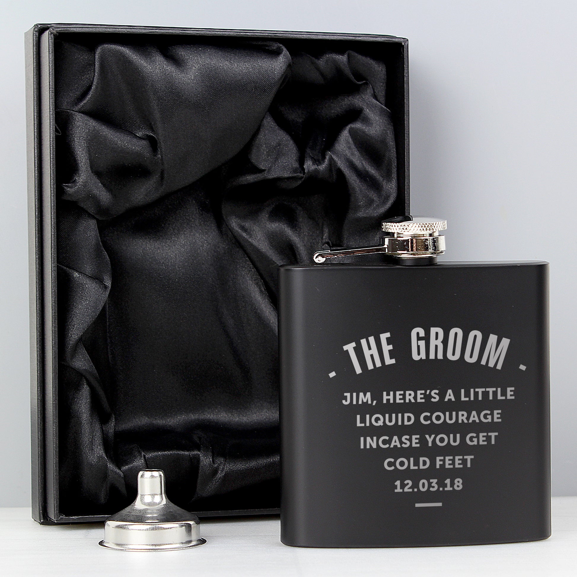 Black flask with engraved text in a black satin-lined box