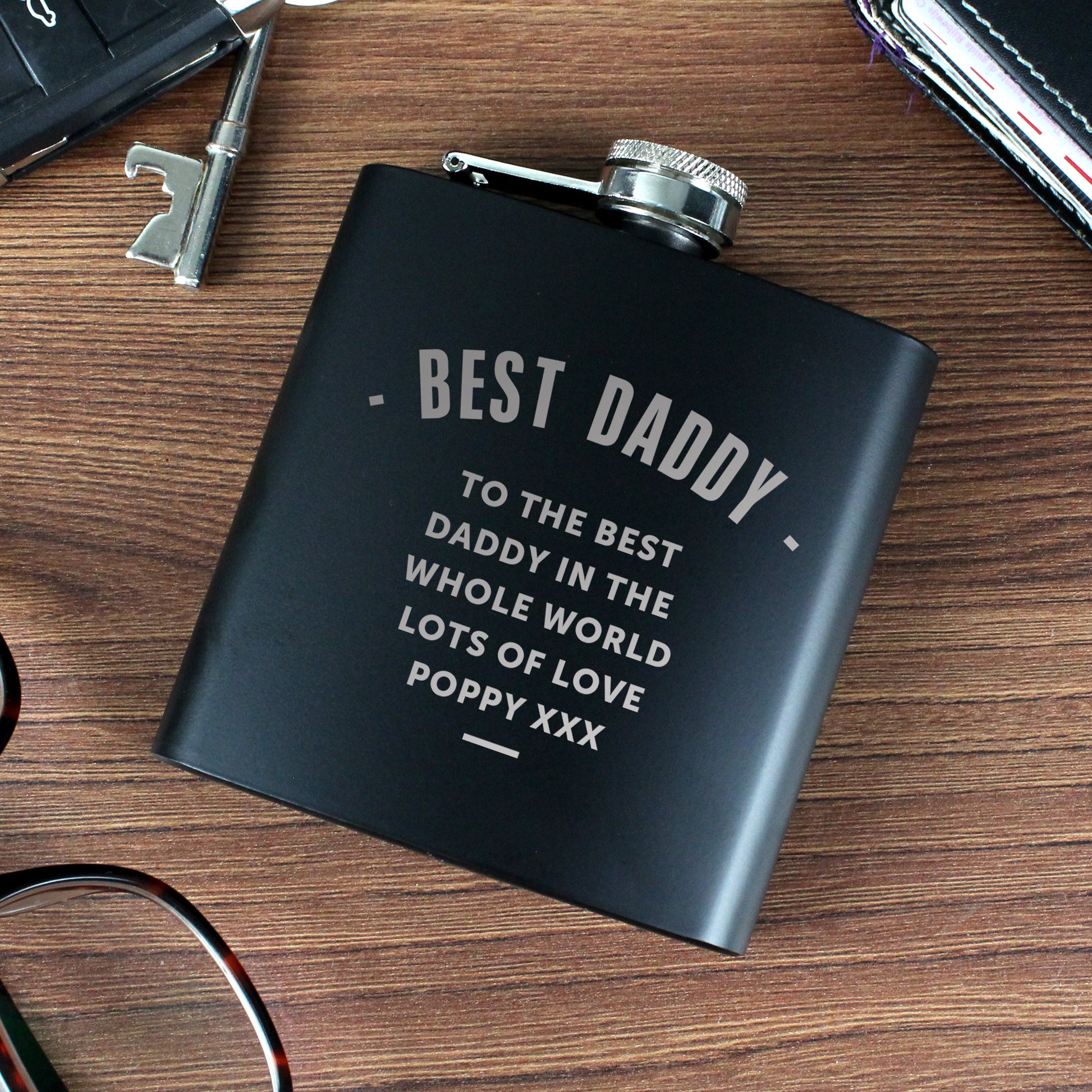 Black flask with 'Best Daddy' text on a wooden surface